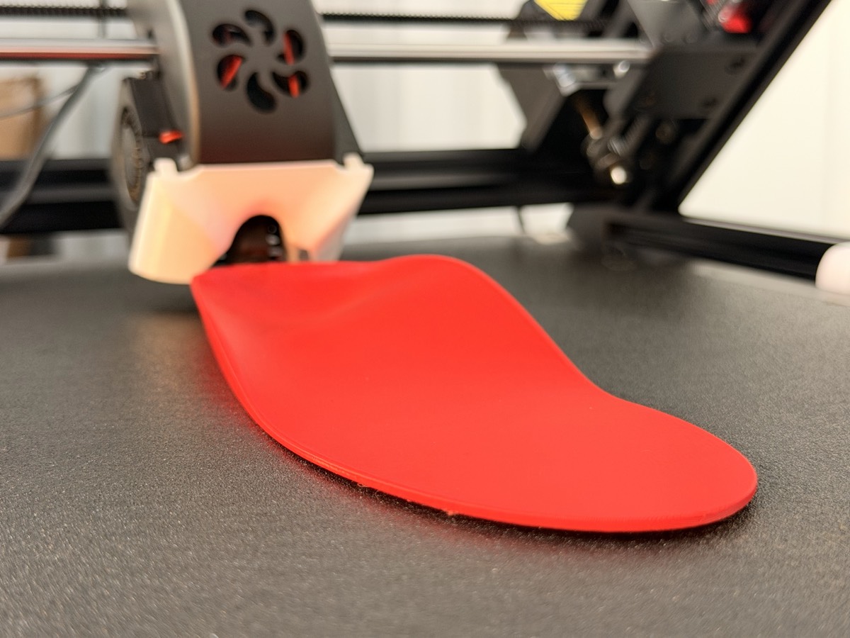 A red NuSoulz insole on the 3D printer bed
